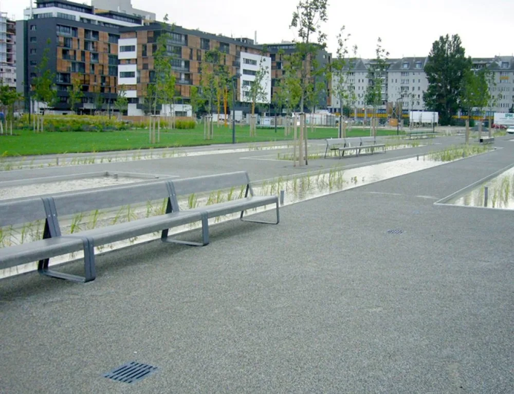 Bednarpark mit Wasserbecken, Bänken und Wohnhäusern im Hintergrund