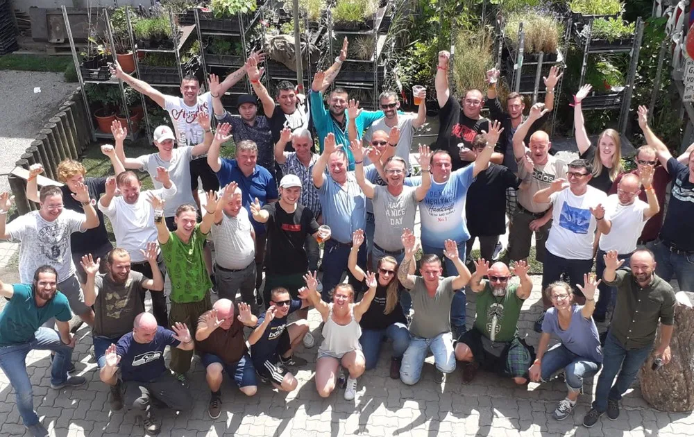 Gruppenbild des Eichhorn-Teams mit erhobenen Armen zwischen Pflanzen